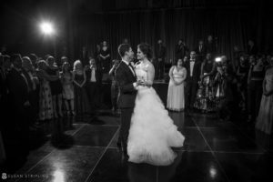 A bride and groom sharing their first dance at a summer wedding at Cipriani 42nd Street, surrounded by a large crowd.