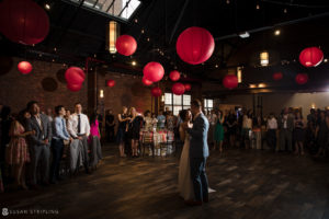 A bride and groom dance at the 26 Bridge wedding venue, surrounded by red paper lanterns.