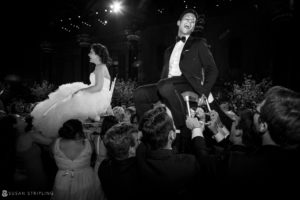 A summer wedding at Cipriani 42nd Street, with a bride and groom elegantly clad in tuxedos.