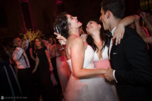A summer wedding reception at Cipriani 42nd Street, with the bride and groom hugging on the dance floor.