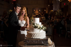 A bride and groom cutting their wedding cake at Union Trust in Philadelphia.