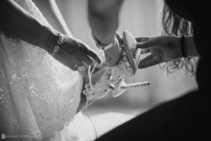 The bride is getting ready for her wedding at Flowerfield Celebrations and putting on her wedding shoes.