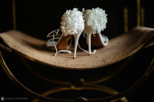 A pair of white wedding shoes sitting on a chair at the Bridgehampton Tennis and Surf Club.
