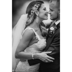 A black and white photo of a bride and groom sharing a kiss at their wedding.