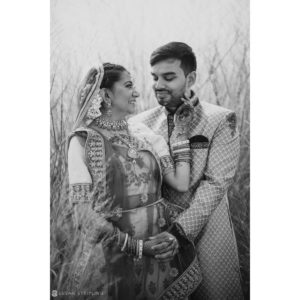 A black and white photo of an indian couple in a field, capturing the essence of a serene and romantic Spa Wedding.
