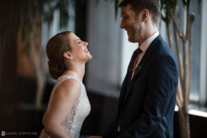 A wedding couple in Philadelphia's Loews Hotel are smiling at each other.