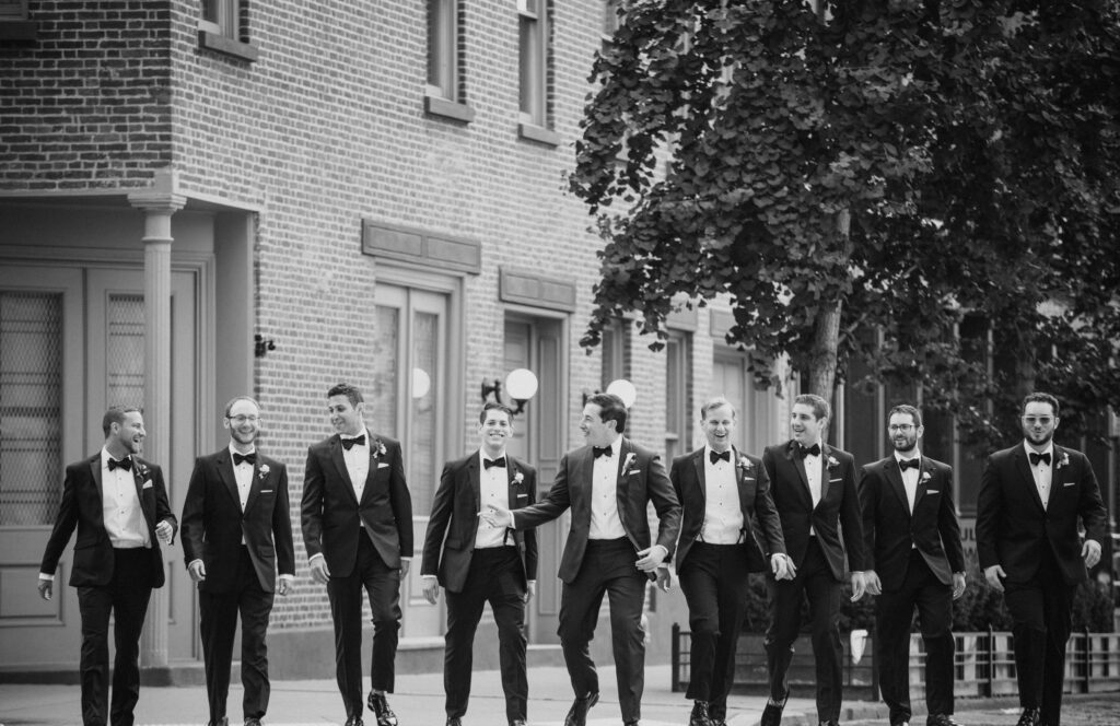 Groomsmen in tuxedos walking down the street during a wedding at Pier Sixty.