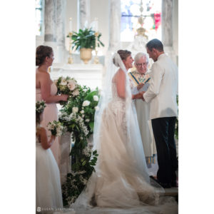 A bride and groom exchange vows at a wedding ceremony in a church.