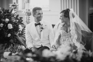 A bride and groom smiling at each other during their wedding at the Berkeley Oceanfront Hotel in a black and white photo.
