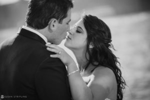 A black and white photo of a bride and groom sharing a passionate kiss on their wedding day at Pier Sixty.