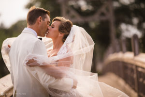 A bride and groom sharing a romantic kiss on their wedding day at the Berkeley Oceanfront Hotel.