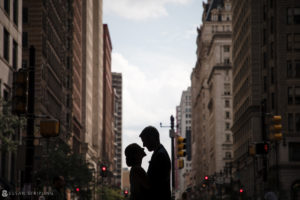 A bride and groom are silhouetted in the middle of a city street in Philadelphia.