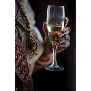 An Indian bride at Ocean Place Resort, holding a glass of champagne.