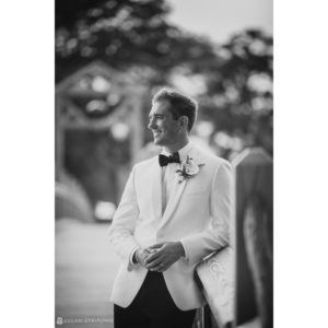 A black and white photo of a groom at a wedding, wearing a tuxedo at the Berkeley Oceanfront Hotel.