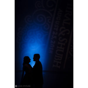 A silhouette of a couple standing in front of a blue light at Ocean Place Resort.