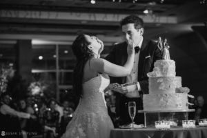 A wedding at Pier Sixty with the bride and groom cutting their wedding cake.