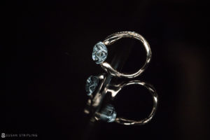 A blue topaz ring perfect for a summer wedding, showcased against a striking black background at Riverside Farm.