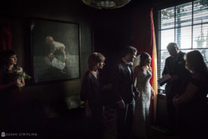 A wedding couple standing in front of a painting at the Gramercy Park Hotel.