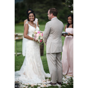 A wedding couple smiling at each other during their Riverside Farm ceremony.