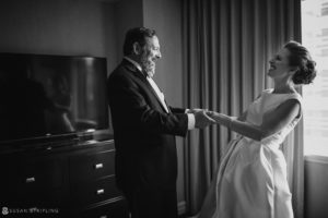 A black and white photo of a bride and groom in front of a window at their wedding at the Westin in Philadelphia.