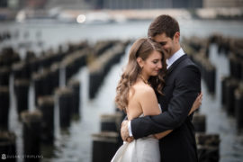 A bride and groom hugging in front of the Hotel Brooklyn Bridge.