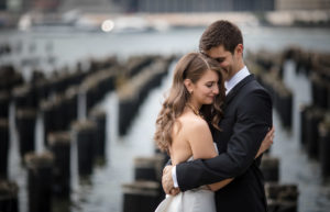 A bride and groom hugging in front of the Hotel Brooklyn Bridge.