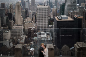 A bride and groom eloping on top of the Rockefeller Center, overlooking the city.