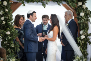 A New York bride and groom exchange vows under a wedding arch in Bridgehampton.