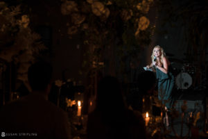 A woman is singing at a wedding reception at 1 Hotel Brooklyn Bridge.