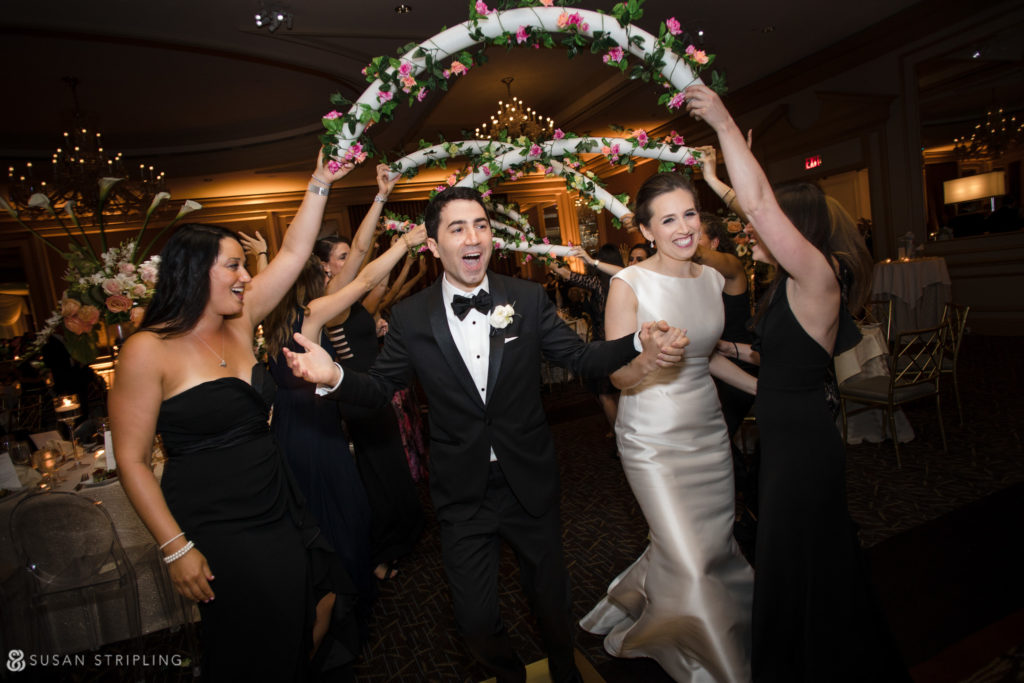 bride and groom enter jewish wedding reception under arches