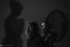 A woman is getting ready for her wedding in front of a mirror at the Sleepy Hollow Country Club.