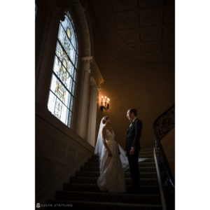 A wedding couple standing on the stairs of the Sleepy Hollow Country Club, an ornate building.