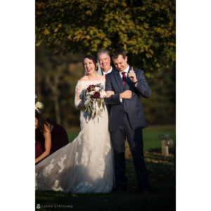 A bride and groom walking down the aisle at a Fall wedding at Riverside Farm.