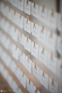 A row of place cards hanging on clothes pins at a Riverside Farm wedding in the Fall.