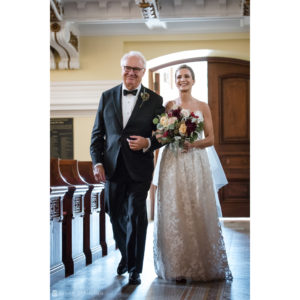 A bride walks down the aisle at her wedding with her father at Sleepy Hollow Country Club.