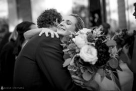 A bride and groom hugging outside the Sleepy Hollow Country Club after their wedding.