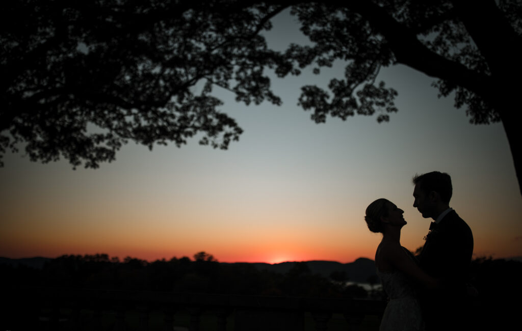 A wedding couple is silhouetted against the sunset at Sleepy Hollow Country Club.