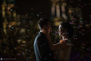 A bride and groom embracing on a rooftop in Tribeca at night for their wedding.