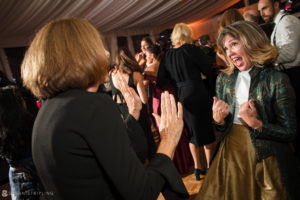 A woman clapping at a wedding party at Sleepy Hollow Country Club.
