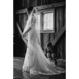 A bride is getting ready for her wedding in a rustic barn at Riverside Farm.