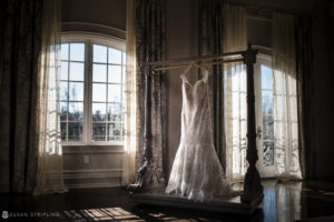 A wedding dress hangs in the elegant Park Chateau, surrounded by large windows offering a breathtaking view.