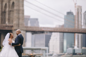 Wedding couple standing in front of the Brooklyn Bridge at 501 Union.