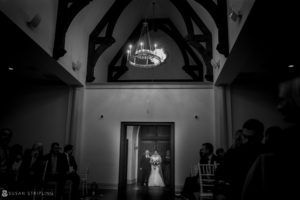 A black and white photo of a bride and groom walking down the aisle at their Park Chateau wedding.
