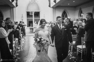 A bride and groom walking down the aisle at their Wedding.