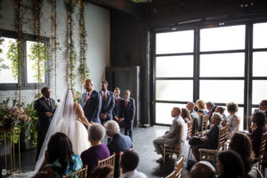 A wedding ceremony at 501 Union, a stunning venue with large windows allowing natural light to flood the room.