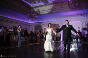 A bride and groom walking down the aisle at their wedding reception at Park Chateau.