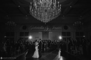 A wedding couple standing in front of a chandelier at Park Chateau.