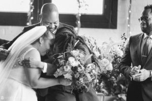 A bride and groom hugging during their wedding ceremony at 501 Union.