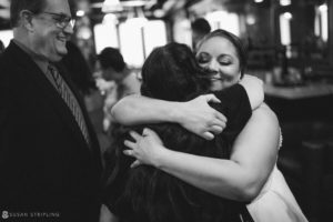 At 501 Union, a bride is hugging her mother in a black and white wedding photo.