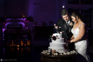 A Park Chateau wedding with the bride and groom cutting their wedding cake.
